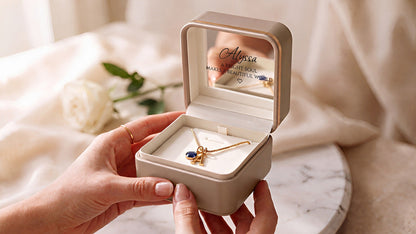 Voraelia personalized initial and birthstone necklace keepsake box held in hands with Alyssa mirror engraving